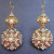 Earrings made with brass filigrees encrusted with pearls, rhinestones, Swarovski crystals, seed pearls, and pearl and crystal components from broken vintage bracelets using fine wire as embroidery "thread." A custom commission. Earrings made with brass filigrees encrusted with pearls, rhinestones, Swarovski crystals, seed pearls, and pearl and crystal components from broken vintage bracelets using fine wire as embroidery "thread." A custom commission.