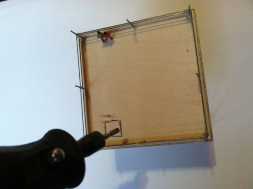 Drill a hole through the square to provide a starting point for the cutting, then cut out the square