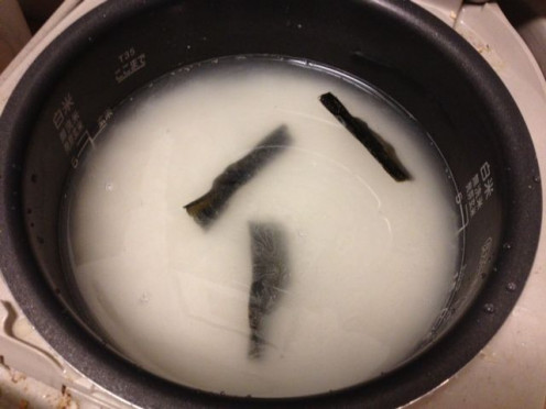 Wash the rice and measure water. Break the konbu stick to fit in your rice cooker.
