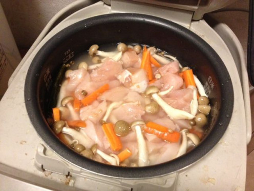 Shimeji, carrots and chicken are all added into the rice cooker on top of the washed rice. Add the seasonings. Turn on the rice cooker and wait for it to finish cooking.