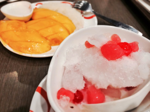 Dessert of sweet mango with sticky coconut rice and a bowl of sweets with shaved ice in coconut milk.
