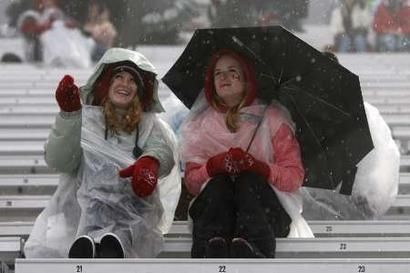 Fans watch snowboarders - "It's raining.  Soooo?"