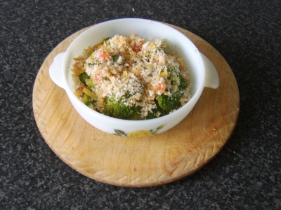 The cheese crumble is scattered over the cooked broccoli
