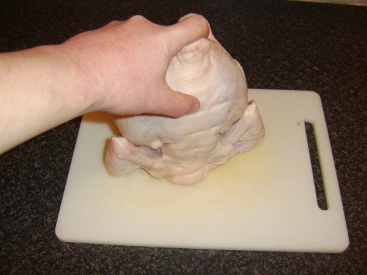 Thumb is pressing on the backbone of the chicken