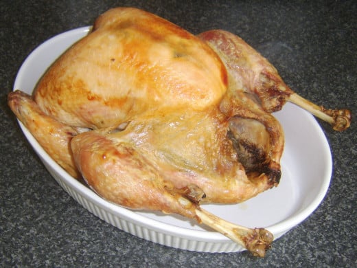 The rested roast turkey is laid in a large serving dish