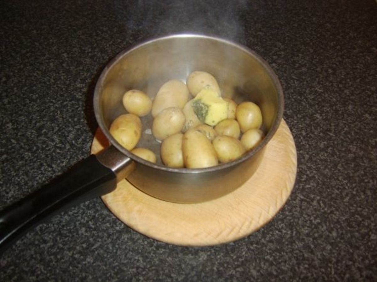 Herb butter is added to the drained potatoes