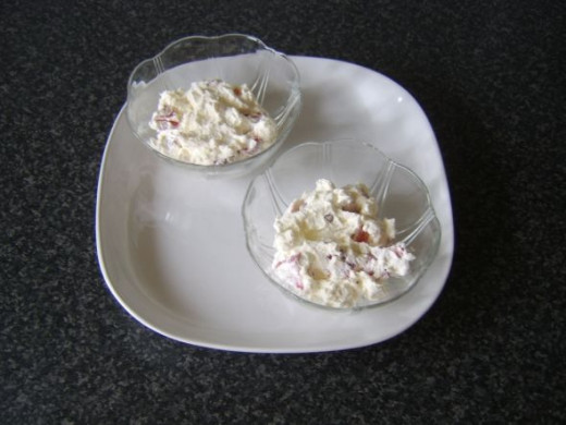 Strawberries and whipped cream added to serving dishes