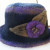 Black and purple yarn were combined to create contrasting borders to this hat. Leaves and a beaded flower were added to add some pizazz.