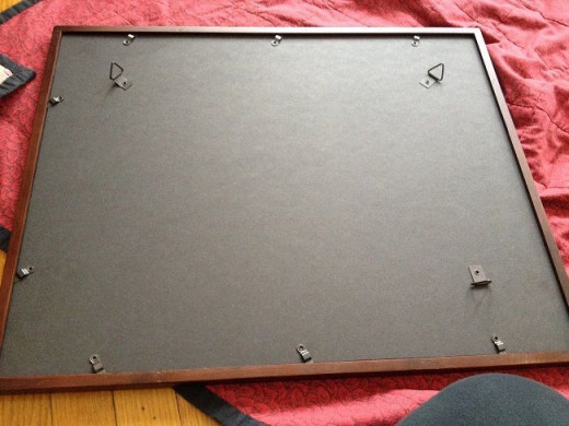 Step 8. Place the assembled paper, backing and matting against the glass, reassemble the frame and lock the back into place.