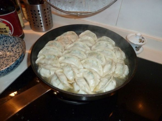 Dumplings cooking in the pan.  Yum!!!  We like to boil them until the water is gone and then fry them until the bottom is crispy.  SO GOOD!