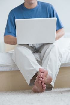 Man Using Laptop Without Laptop Stand Probly With A Hurt Back