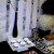 Left side - black bottle w/ black &amp; white striped feather ball stem on riser, pedestal platter with cupcakes, flat square platter with strawberries