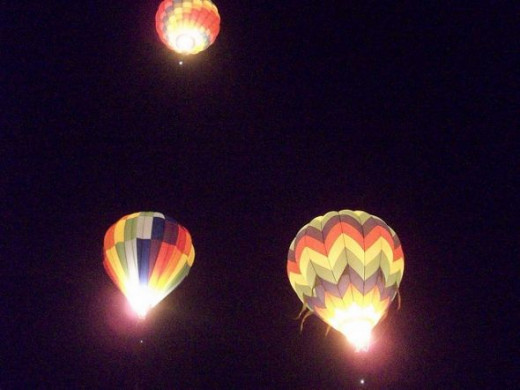 The Glow Show and Dawn Patrol feature balloons lit by their fire and glowing in the pre-dawn darkness