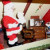 Oh ! Here's Santa hard at work in his workshop... Looks like an elf helps him answer his many letters.