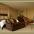 Bedroom has cream and brown color palettes with teak accents Bedroom has cream and brown color palettes with teak accents