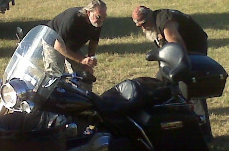 A couple of bikers comparing notes on new paint job on bike.