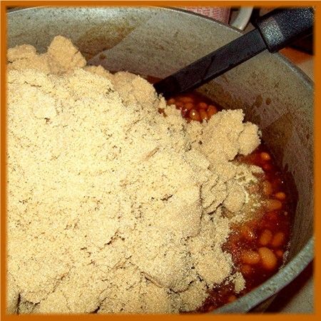 Once the beans are hot, lower the heat and add a whole 2 pound bag of brown sugar.