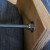 Place a washer on the top side of the bottom board around the bolt, and use the combination and socket wrenches to crank down the nylon nut all the way to the bottom where it meets the washer. When you're done, you'll see in layers, from the bottom Place a washer on the top side of the bottom board around the bolt, and use the combination and socket wrenches to crank down the nylon nut all the way to the bottom where it meets the washer. When you're done, you'll see in layers, from the bottom