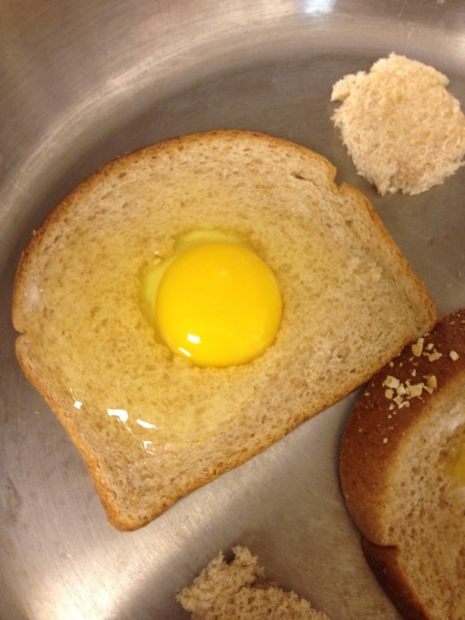 Pour the egg into the cut out center of the bread.