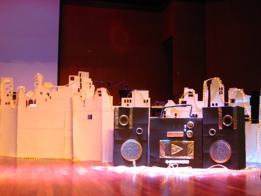 The stage props are all recycled from carton boxes and cardboards. Thanks to a team of ingenious friends. We managed to produce the entire "cityscape &amp; the mini combo" over a spend of 3 weekends!