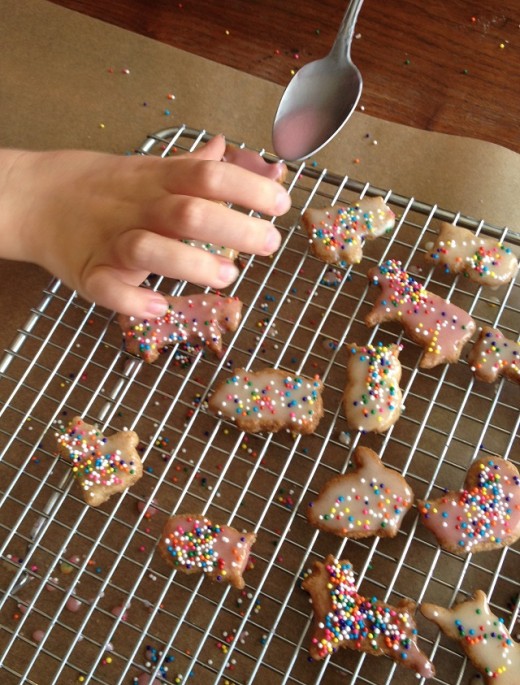 Spooning the icing over one of the tiny cookies