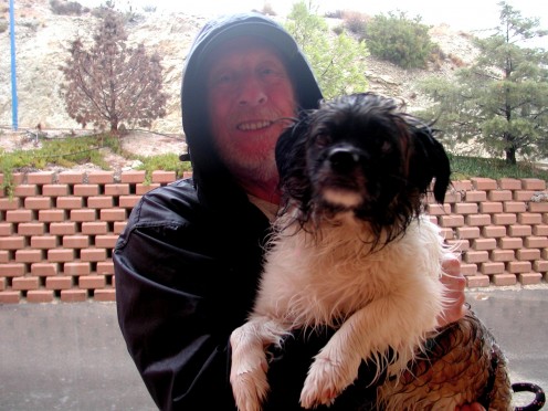A smiling Malcolm just back from a walk in the rain with a wet not so happy Scraggy