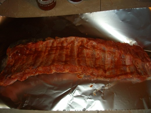 After applying BBQ sauce, wrap your ribs in foil, then set aside to rest.  Start a fire in your smoker.
