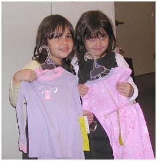 Two young girls get their new PJs from the Pajama Program