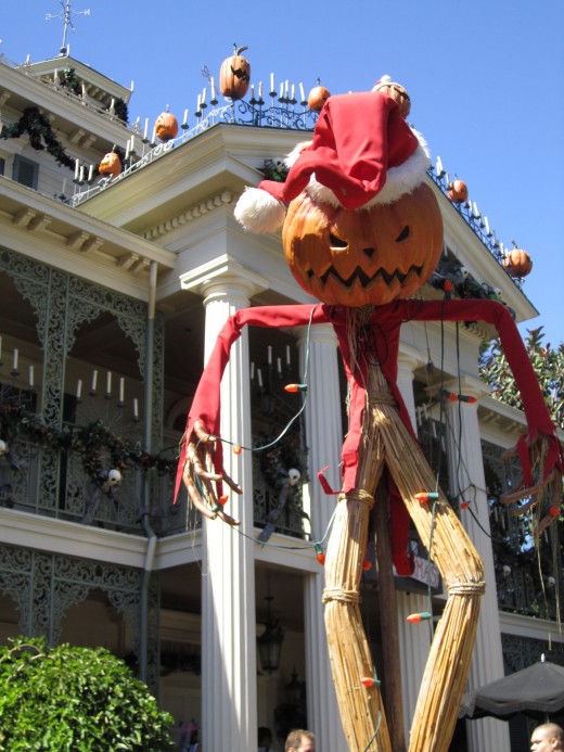 The pumpkin scarecrow in front of the mansion.