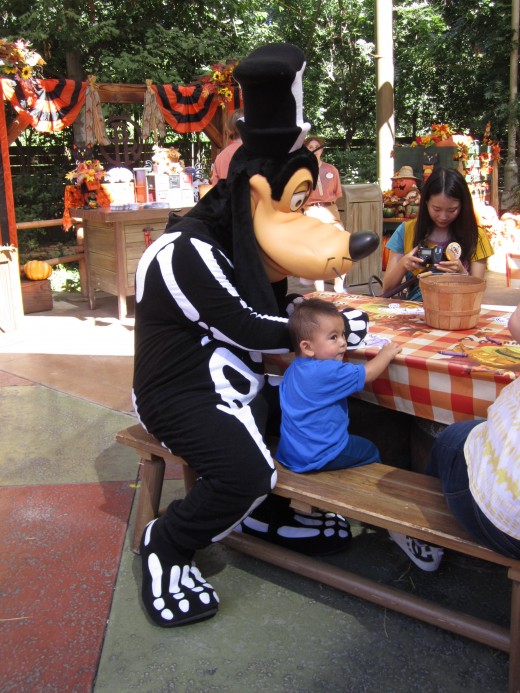 Here is Goofy helping a little kid color!