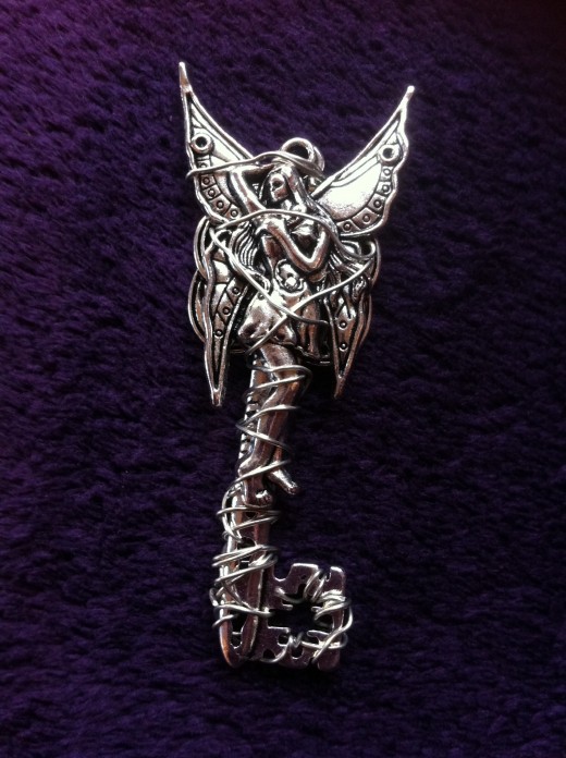 This mystical key pendant- A magical fairy with hand twisting and weaving wire in order to create eye catching and unique neckless.  Pendant measures 6.5 cm including the bail and it can be added to a chain and suspended