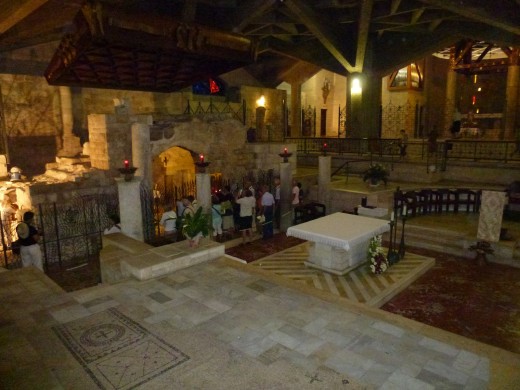 A church is built around the house now, but you can see the grotto behind the altar.