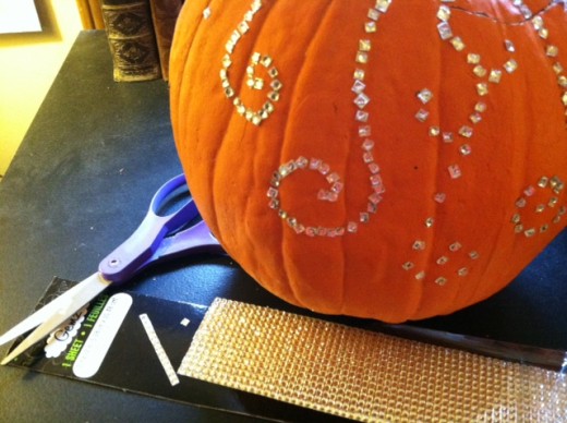 Cut the rhinestones into tiny squares, and then press to apply to pumpkin.