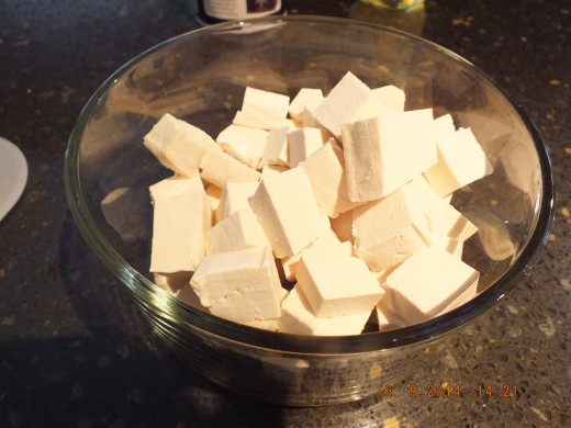 Take your tofu from the tea towel and cut it into bite size cubes. Add the cubes to the poultry seasoning, oil and salt mixture, and gently fold in the tofu.