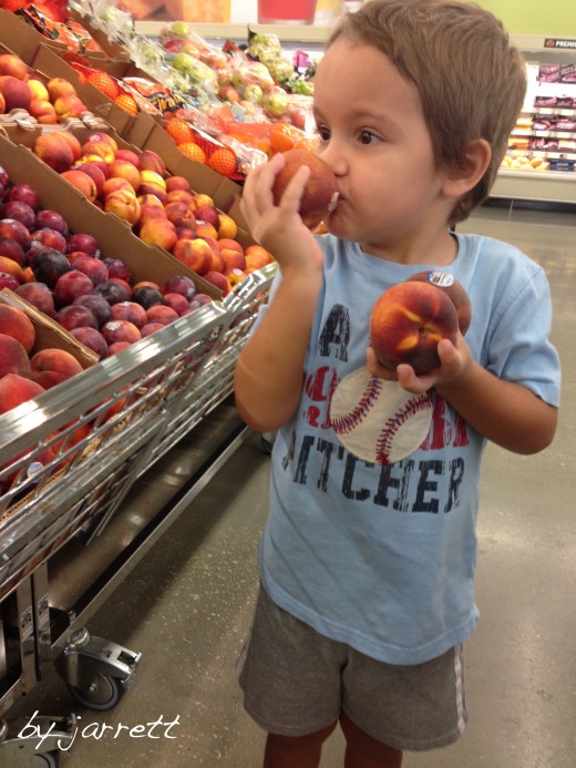 Helping me pick out peaches&hellip;he's smelling them.