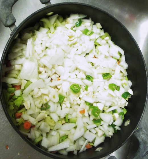 A chopped Mayan onion, a chopped apple, four stalks of chopped celery, and two chopped chili peppers were added to the pot.