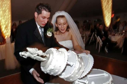 In this photo, the groom causes the wedding cake to tumble, not a hired-guy carrying the cake as in another photo above