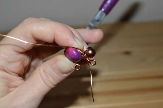 Curling the wire around the handle of the pliers to make a clasp shape