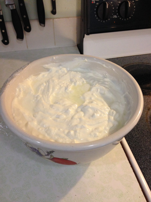 Big bowl of Greek yogurt ready to eat.  You can see a little clear yellow whey separated on top of the yogurt
