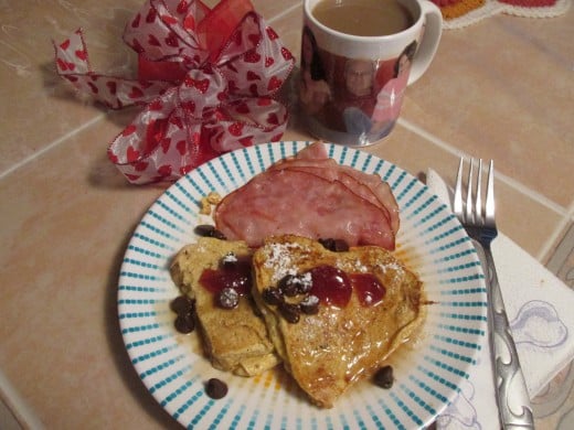 Heart shaped French Toast with strawberry jam, chocolate chips, maple syrup and ham. The pictures on the cup are some of my Valentines.  My husband and two of my granddaughters.