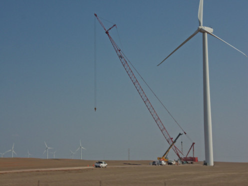 In this photograph they are just finishing up on the erection and construction of a windmill. 