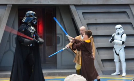 Young visitors to Disney's Hollywood Studios test their light saber fighting skills against Darth Vader