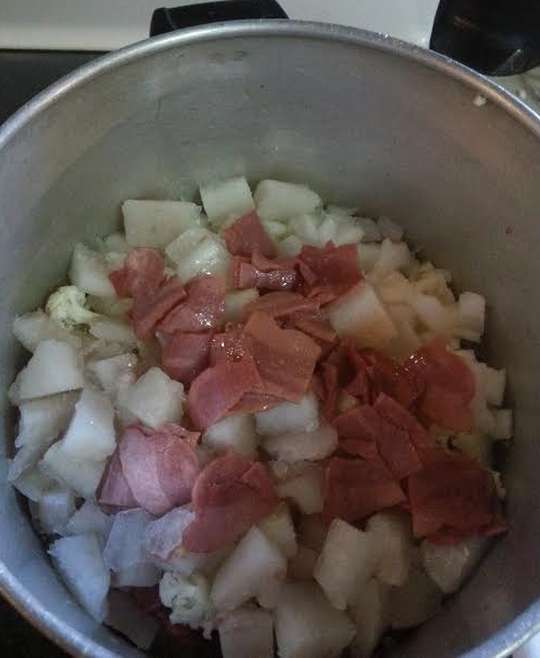 Three layers of fish cubed, cauliflower chopped. onion chopped and turkey bacon.