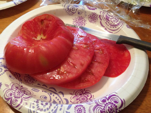 An organically grown brandywine tomato from the 2014 garden that is sliced and ready for eating.