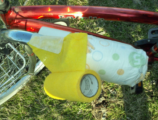 Set the vet wrap at an angle on the handlebar to prepare for wrapping the diaper.
