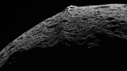 This huge 12 mile tall equatorial ridge, makes Iapetus seem joined together like a peach pit or seed.