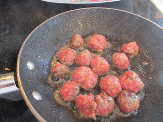 Browning the meatballs in a skillet
