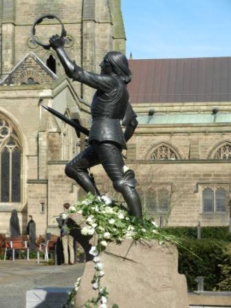 The statue of King Richard III stands outside Leicester Cathedral and on the morning after the reinterment is strewn with white roses representing the House of York.