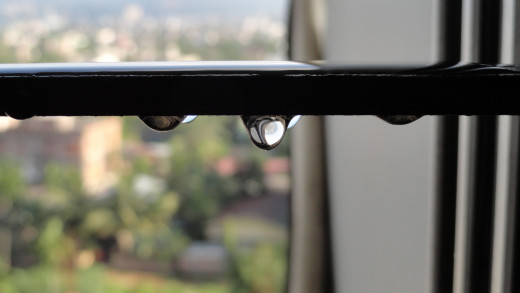 Dangling drops of water from the window....drops after a heavy rain...and Son caught the very moment.