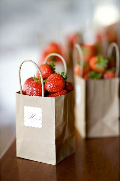 Strawberries in small paper bags as table numbers